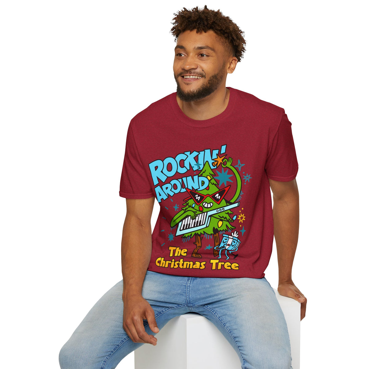 Person wearing a Retro christmas Music Inspired red t-shirt with a colourful graphic of a Christmas tree and text Rockin Around The Christmas Tree
