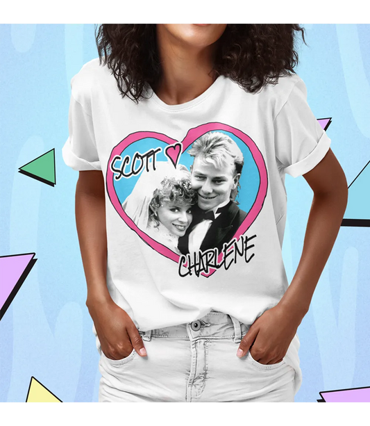 Person wearing a t-shirt with a graphic of two people in a heart and text 'Scott loves Charlene' on a colorful geometric background.