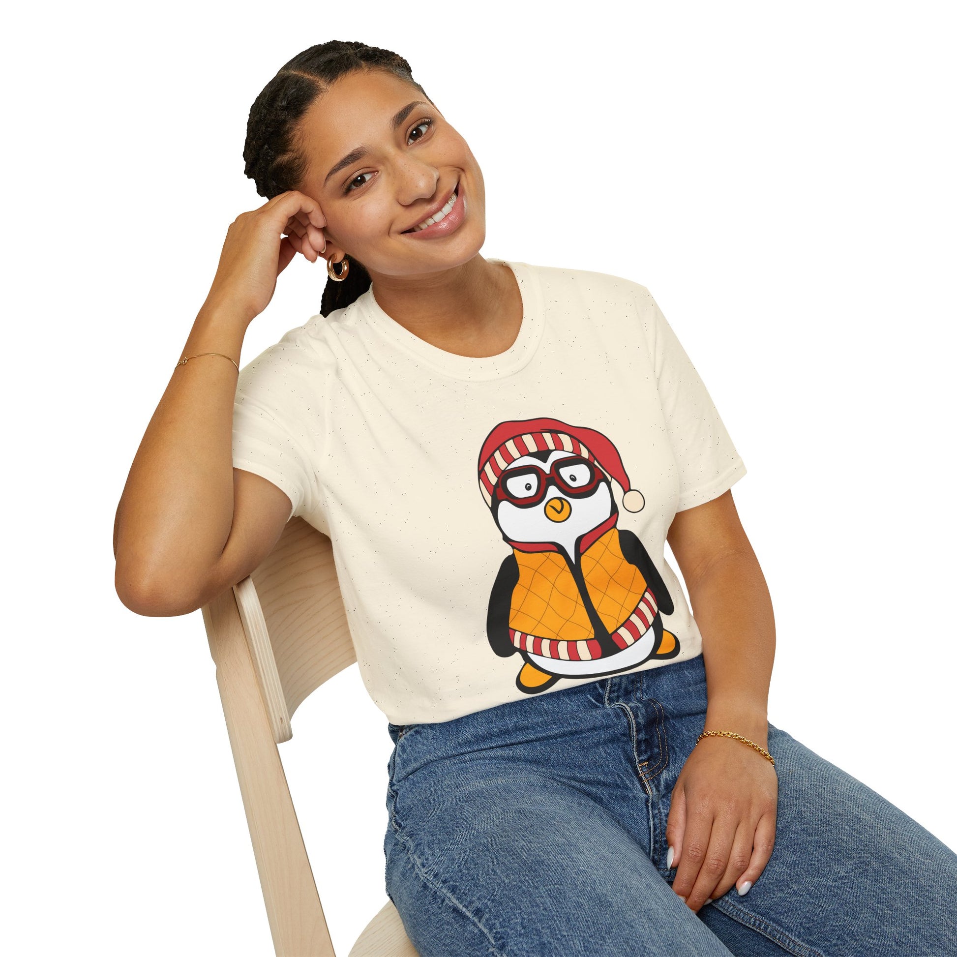 Person wearing a white t-shirt with a penguin graphic and I need a Hugsy text  whilst sitting on a chair.