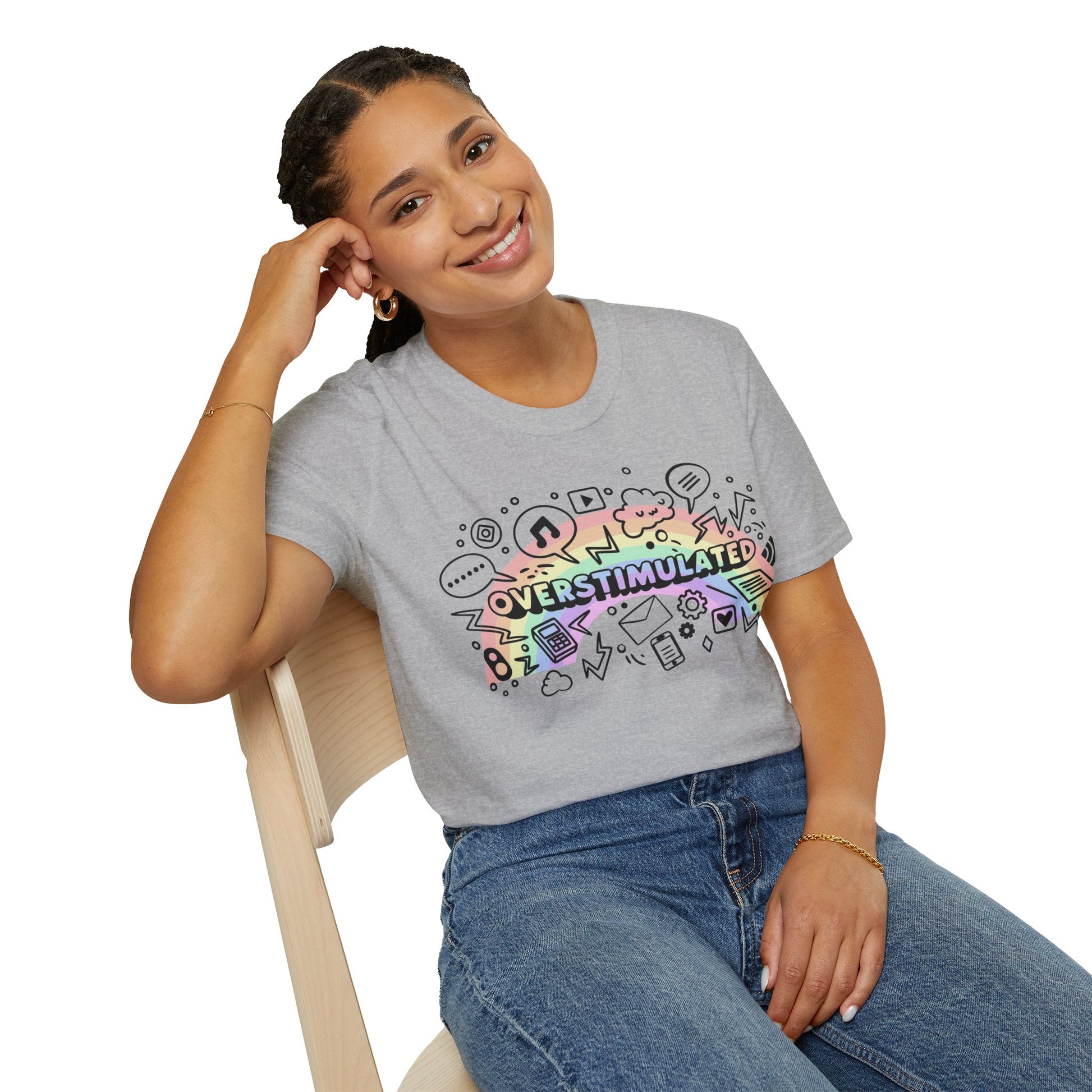 Person wearing a gray t-shirt with colorful graphics and text, sitting on a chair.