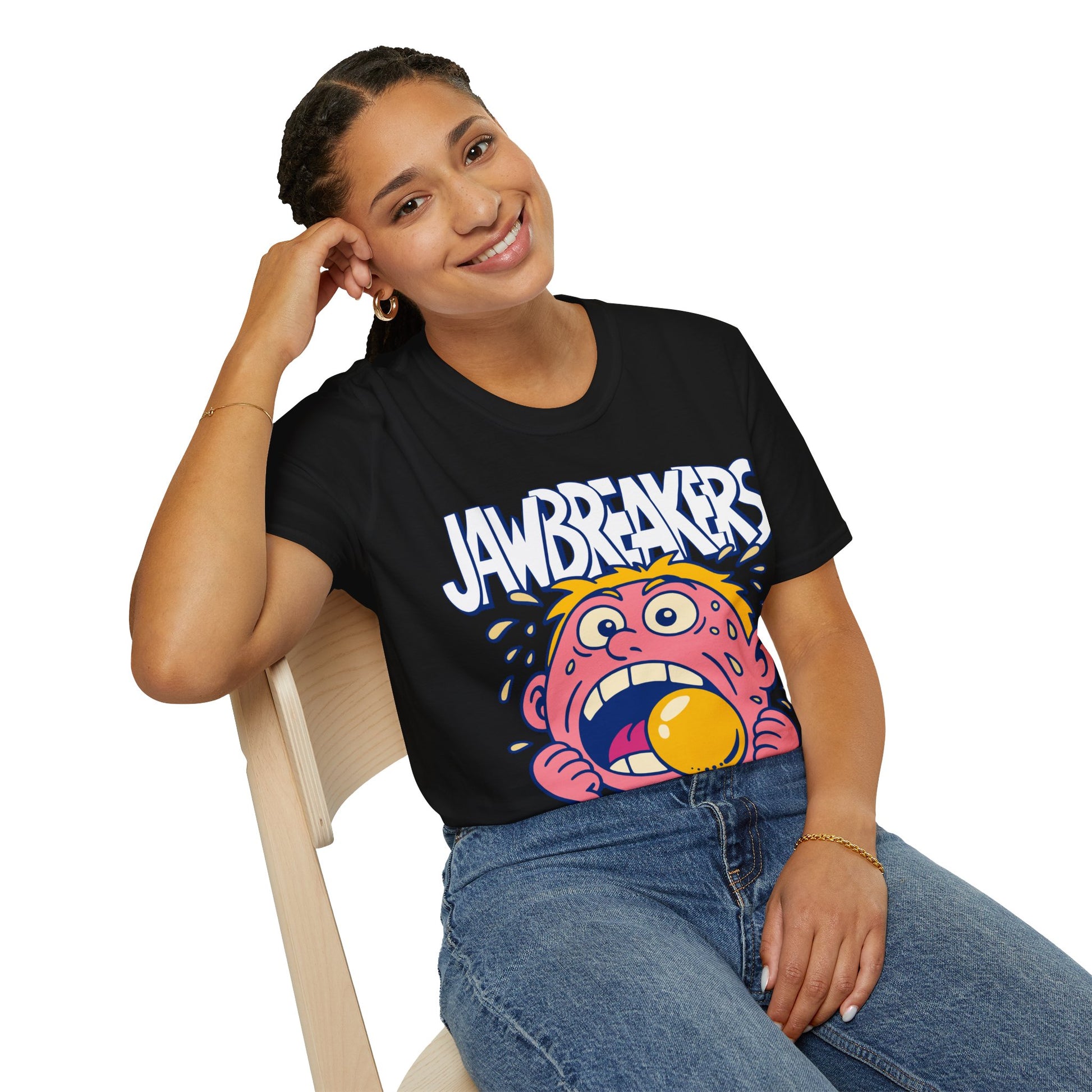 Person wearing a black t-shirt with a colorful graphic and 'Jawbreakers' text, sitting on a chair.