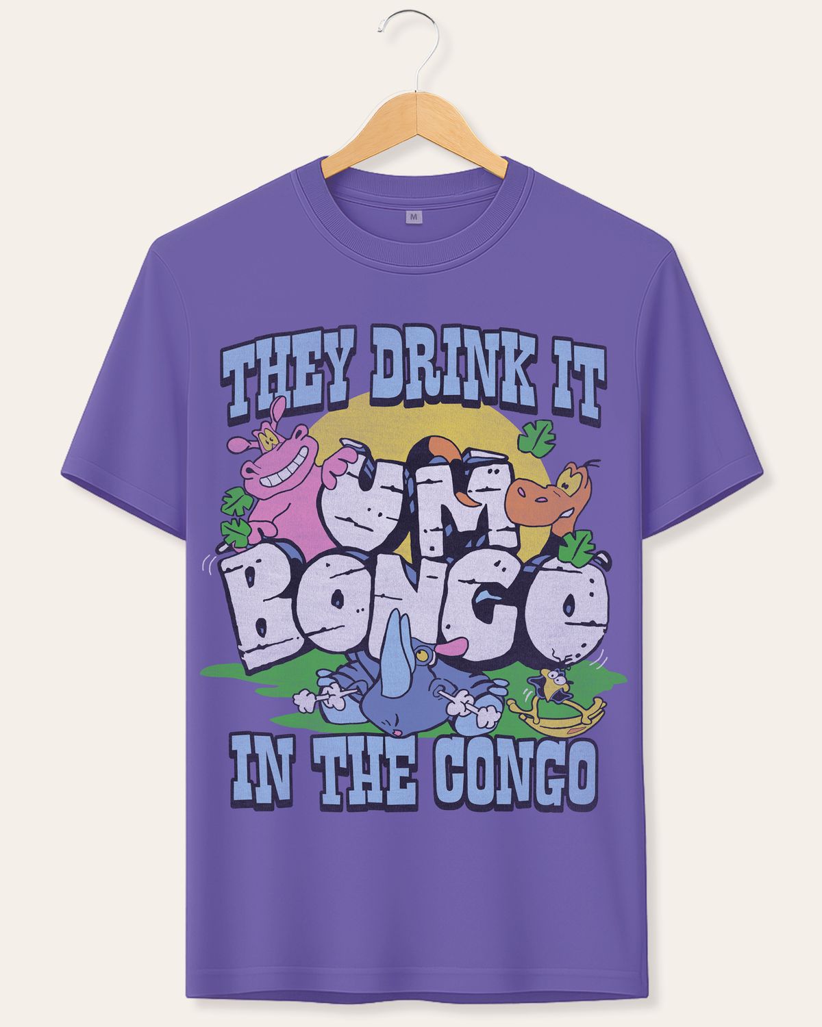 A purple short-sleeve graphic t-shirt hanging on a wooden hanger against a light beige background. The shirt features a colorful cartoon design of apes and a blue bird with the text 'THEY DRINK IT IN THE CONGO'.