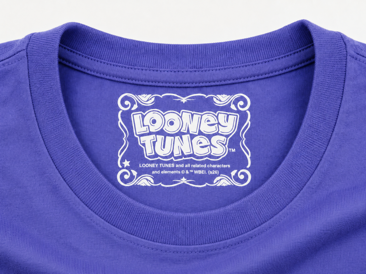 Close-up of a dusk blue crewneck t-shirt featuring a white Looney Tunes graphic printed inside the collar.