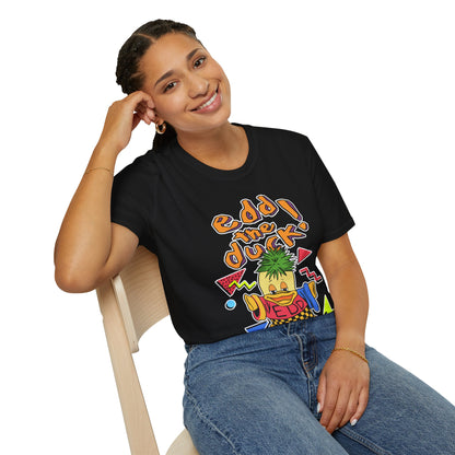 Person wearing a black t-shirt with colorful 90s graphics and text whilst sat on a chair.