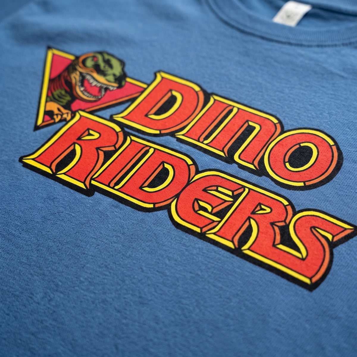 Faded denim dino riders logo close up