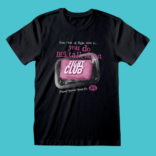 A black short-sleeve crewneck t-shirt featuring a graphic print on the front. The graphic shows a pink bar of soap labeled 'FIGHT CLUB' inside a soap dish, with the text 'first rule of fight club is.