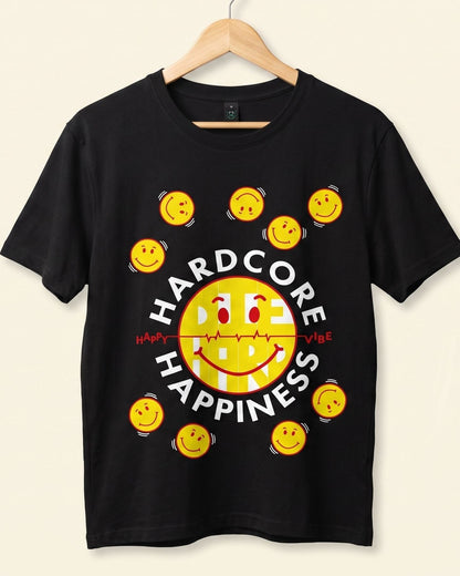 A black short-sleeve t-shirt hanging on a wooden hanger against a light beige background. The shirt features a graphic design with the words 'HARD CORE HAPPINESS' in white, surrounding a large yellow smiley face and smaller yellow smiley faces arranged around it.