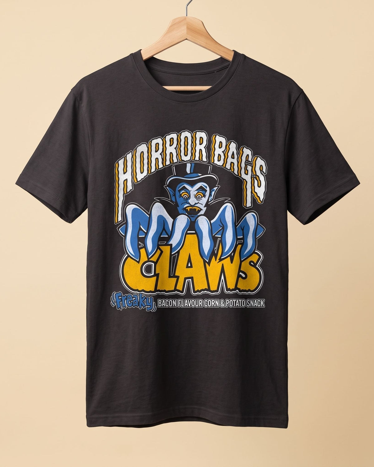 A black graphic t-shirt hanging on a wooden hanger against a solid beige background. The shirt features a large front graphic with the text 'HORROR BAGS' in white, a blue cartoon character wearing a top hat, and 'CLAWS' in yellow.