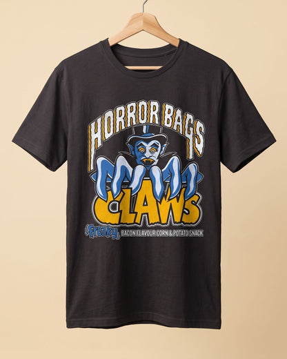 A black graphic t-shirt hanging on a wooden hanger against a solid beige background. The shirt features a large front graphic with the text 'HORROR BAGS' in white, a blue cartoon character wearing a top hat, and 'CLAWS' in yellow.
