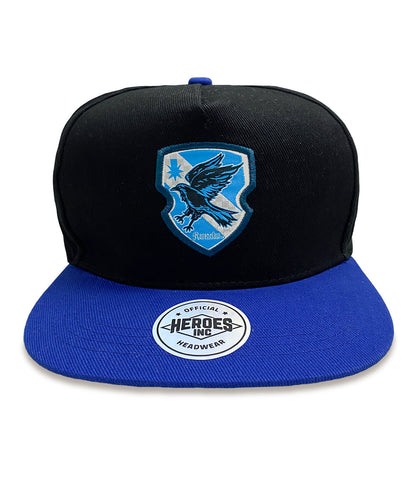 A black and blue unisex snapback cap with a Harry Potter Ravenclaw badge design on the front.