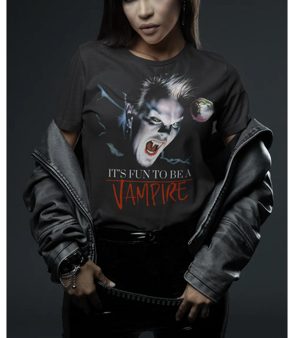 premium vintage washed black unisex short sleeve crew neck t shirt laying on blue background featuring The Lost Boys movie inspired colour Vampire design to the front of t-shirt with text Its Fun To Be A Vampire