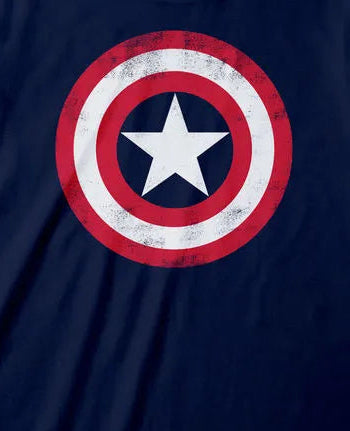 A navy blue short-sleeve t-shirt featuring a distressed Captain America shield graphic on the chest, displayed against a solid pale yellow background.