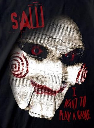 Black short sleeve T-shirt featuring a lose up eerie Saw horror movie face and I want to play a game Text