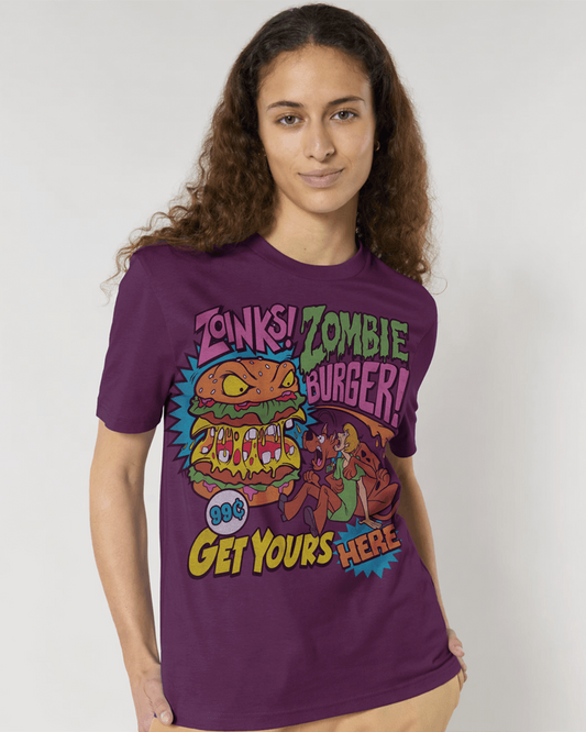 A woman modeling a deep plum short-sleeve t-shirt with a colourful retro graphic that reads 'Zonks! Zombie Burger! 90s Get Yours Here!' featuring cartoon burgers and Scooby Doo  characters, against a plain light gray background.