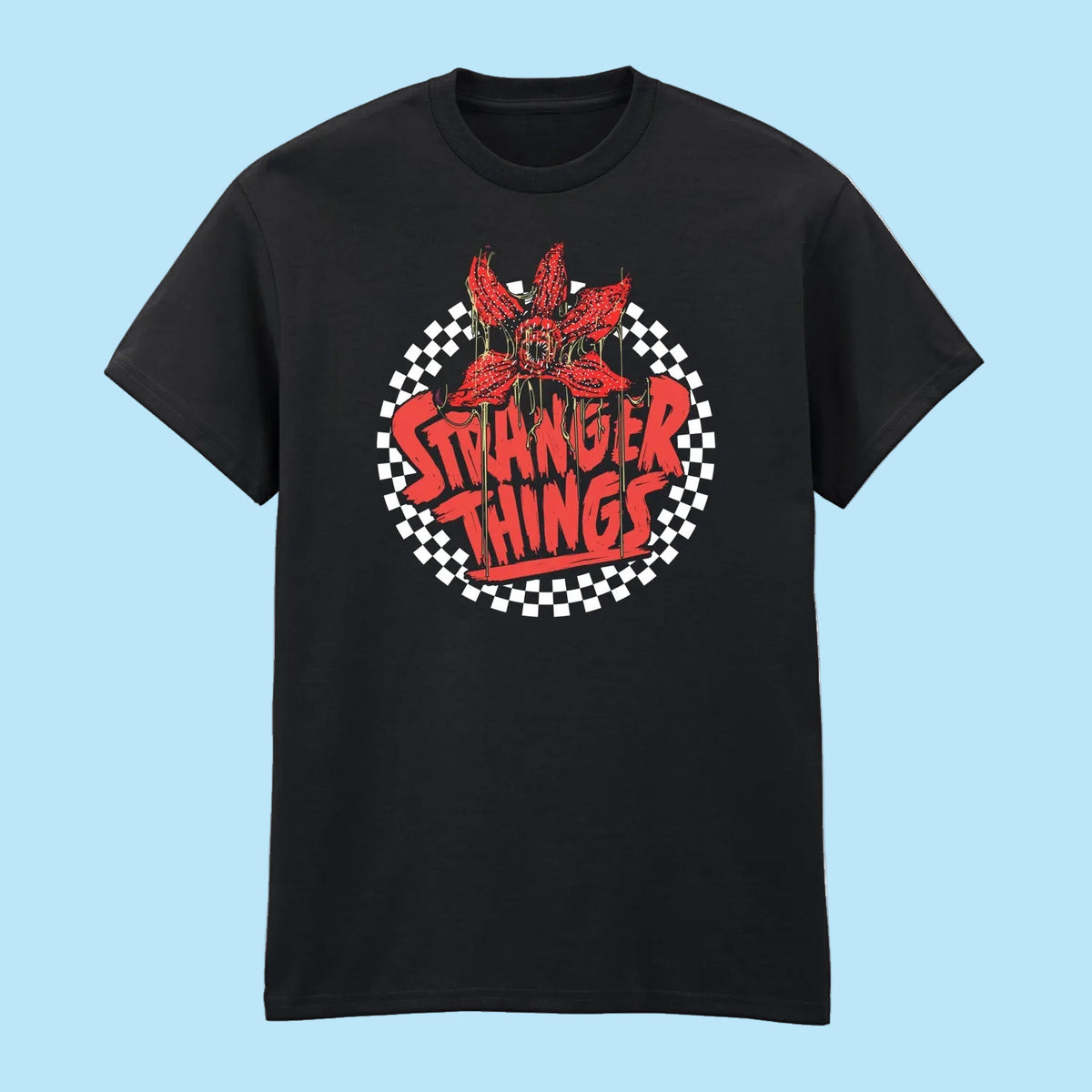 A black short-sleeve crewneck t-shirt featuring a circular graphic on the chest with a red flower, the words 'STRANGER THINGS' in red, and a black-and-white checkered circle background.