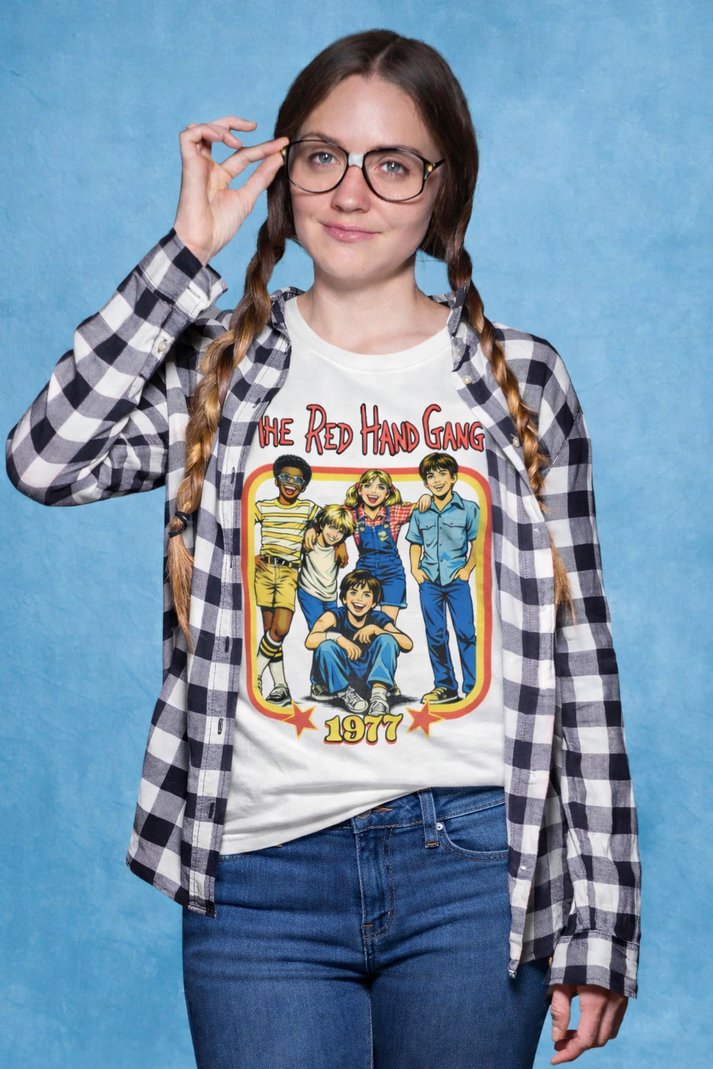 Person wearing a checkered shirt over a graphic t-shirt with 'The Red Hand Gang' design on a blue background