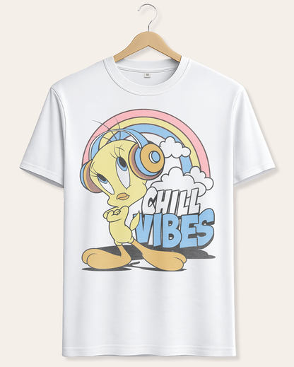 A white short-sleeve crewneck t-shirt hanging on a wooden hanger against a light beige background. The shirt features a colorful graphic of Tweety Pie wearing headphones under a pastel rainbow with the text 'CHILL VIBES'. Official Looney Tunes