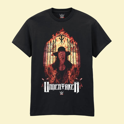 A black short-sleeve crewneck t-shirt featuring a large graphic print of the wrestler Undertaker surrounded by flames, with the 'UNDERTAKER' name and WWE logos printed below.