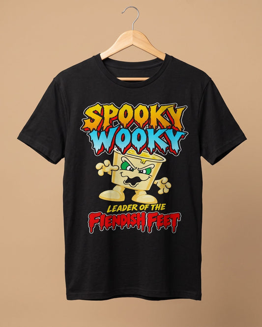A black short-sleeve graphic t-shirt hanging on a wooden hanger against a solid beige background. The graphic features a cartoonish yellow yoghurt pot  character with green eyes and a mustache, with the text 'SPOOKY WOOKY LEADER OF THE FIENDISH FEET' in colorful stylized lettering.