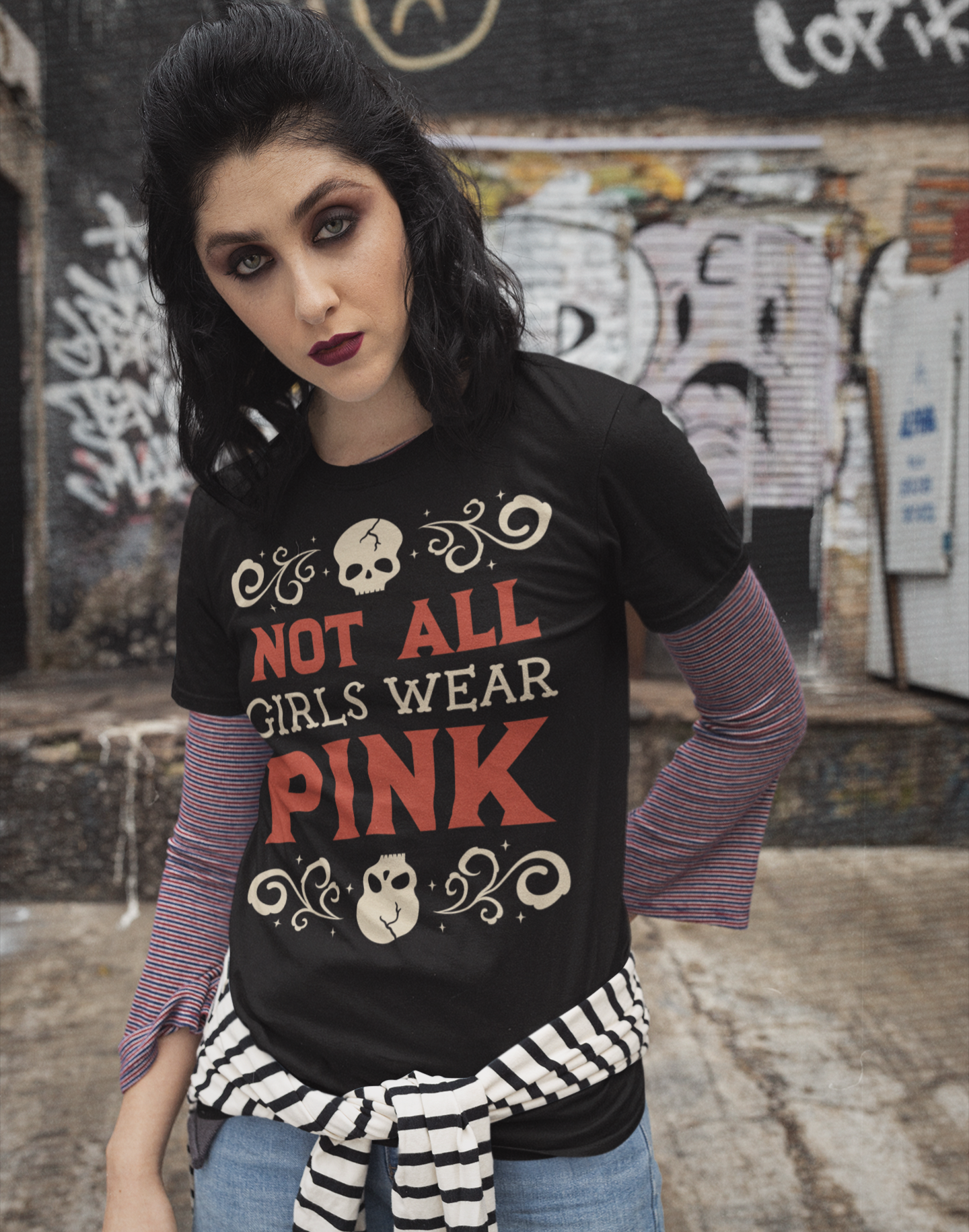 Woman wearing a black t-shirt with 'Not All Girls Wear Pink' text in an urban setting.